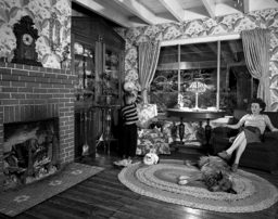 The owner of this house, Hester Fringer, added a larger window to her living room to have a better view of the trains which passed so closely by her house. This photograph shows a mother and son in this living room as a train goes by, the mother with a stern expression and the boy waving at the train. The photograph is framed in such a way that the viewer almost does not notice the train right away, before realizing just how close it is to the window.  