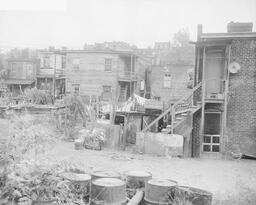 <p>Dilapidated buildings sit amid clutter and refuse in this 1952 photograph of a group of homes between Byrd and Spring Streets in downtown Richmond. The <i>Richmond Times-Dispatch</i> took this picture for an article about potential urban renewal projects, so the photographer intentionally sought out timeworn buildings in the area. It is notable that many photographers took pictures of the rear sides of buildings when illustrating articles about urban renewal.</p> 