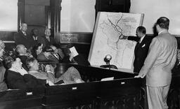 <p>Julian Tarrant, a project manager for the Richmond-Petersburg Turnpike project, presents his map of the “Proposed Interregional Highway Routes” to the Richmond city council at a hearing held on April 13, 1950.</p>