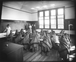 <p>This 1916 photograph shows a class of students at Moore Street School in Richmond, wrapped in blankets, attending class in an “open-air” classroom.</p>