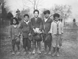 <p>Four young members of the Mattaponi Indian Tribe, several of whom are carrying books, pose for ethnologist Frank G. Speck. From left to right the boys in the picture are: Webster D. Custalow, Melvin L. Custalow Sr., Harvey N. Custalow, Christopher (Kit) Custalow, and Sednoe or Buck Custalow.</p> 